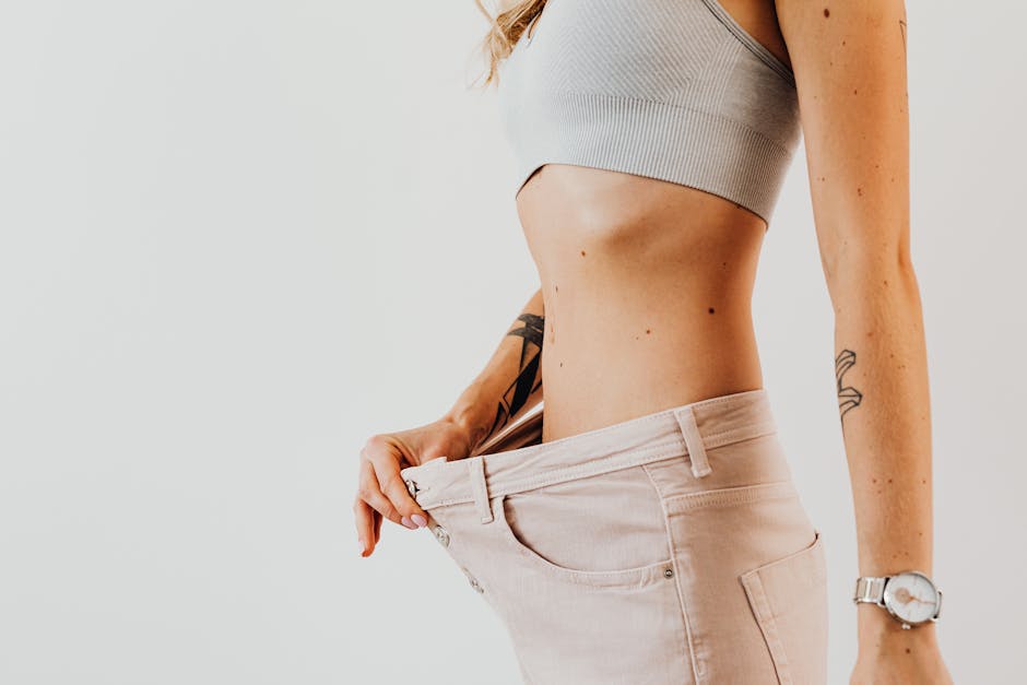 Close-up of a woman in oversized jeans symbolizing weight loss in a studio setting.